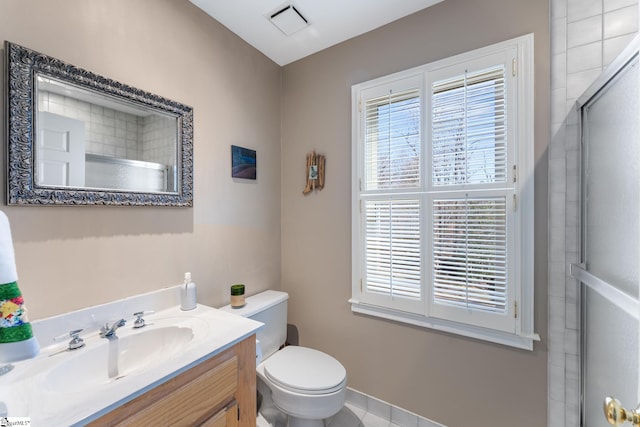 bathroom featuring vanity, a shower with door, and toilet