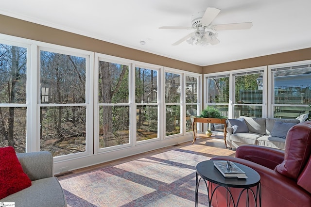 sunroom / solarium featuring a healthy amount of sunlight and ceiling fan