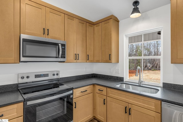 kitchen featuring sink, hanging light fixtures, and appliances with stainless steel finishes