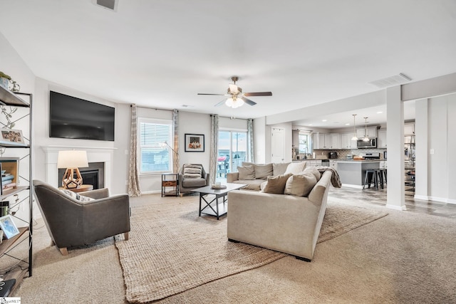 carpeted living room featuring ceiling fan