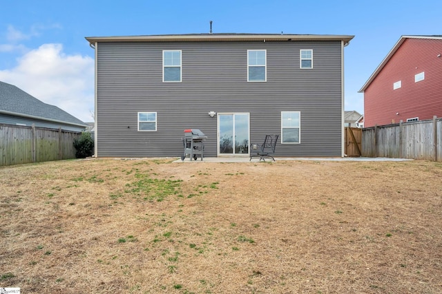 rear view of property featuring a lawn and a patio area