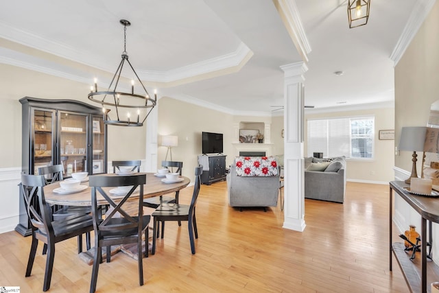 dining room featuring ornamental molding, light hardwood / wood-style floors, and ornate columns