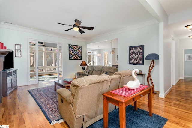 living room featuring crown molding, ceiling fan, and light wood-type flooring