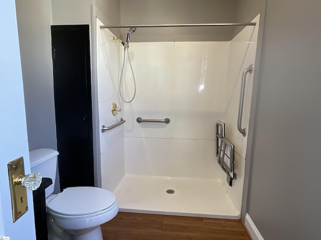 bathroom featuring walk in shower, wood-type flooring, and toilet