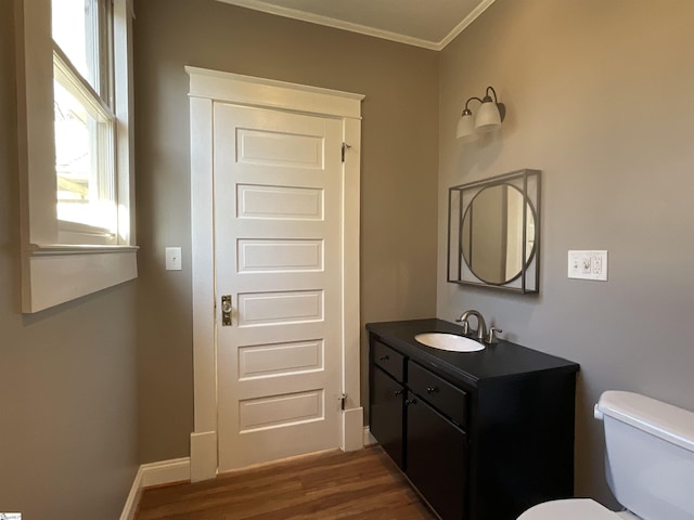 bathroom with vanity, hardwood / wood-style floors, ornamental molding, and toilet