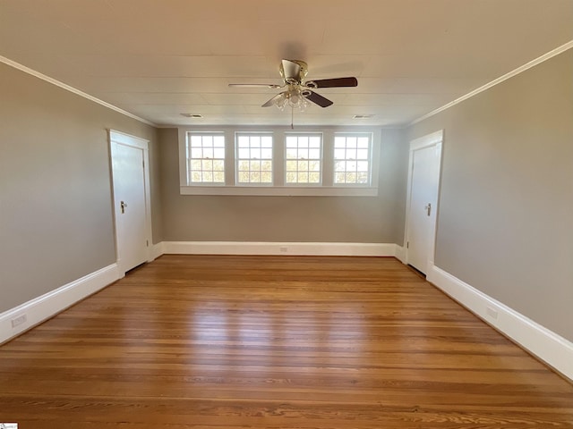 spare room featuring crown molding, plenty of natural light, and hardwood / wood-style floors