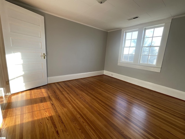 unfurnished room featuring hardwood / wood-style floors and crown molding