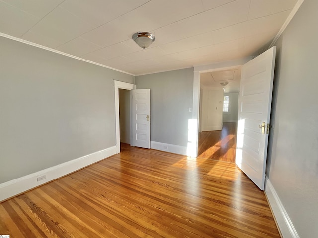 unfurnished room featuring ornamental molding and hardwood / wood-style floors