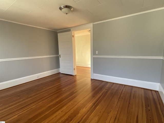 unfurnished room with ornamental molding and dark hardwood / wood-style floors