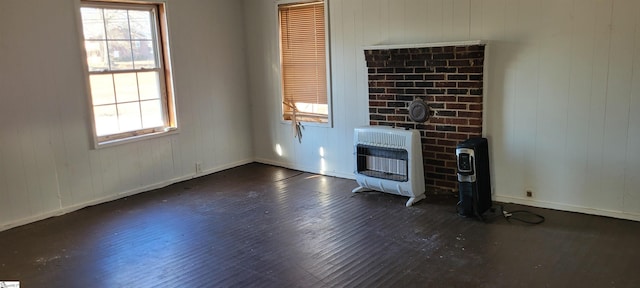 unfurnished living room with dark hardwood / wood-style flooring and heating unit