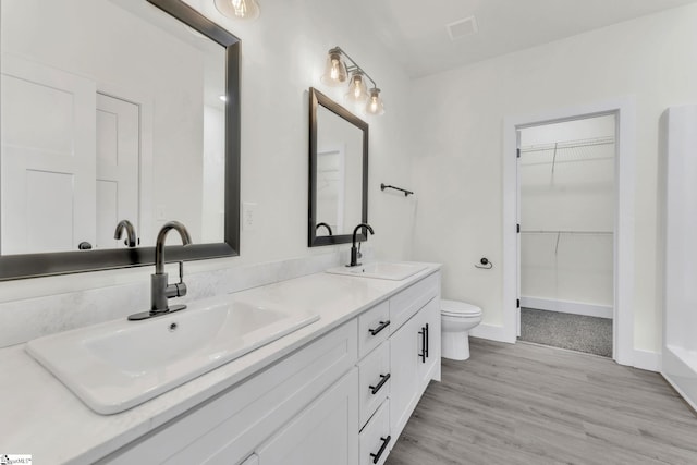 bathroom with vanity, toilet, and hardwood / wood-style floors