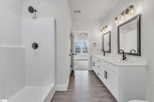 bathroom featuring vanity, hardwood / wood-style floors, and walk in shower