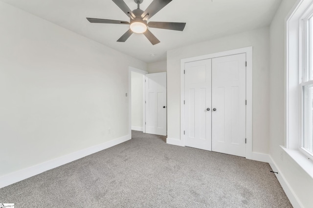 unfurnished bedroom featuring ceiling fan, a closet, and carpet