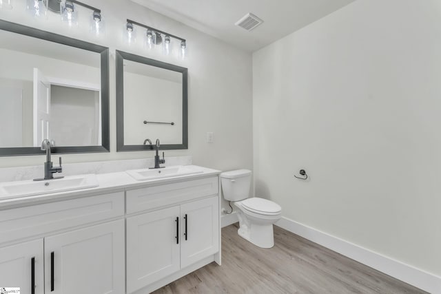 bathroom with hardwood / wood-style flooring, vanity, and toilet