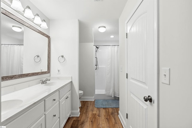 bathroom with wood-type flooring, vanity, and toilet