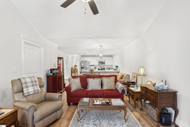 living room featuring crown molding, ceiling fan, and light hardwood / wood-style floors