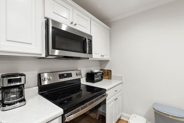 kitchen featuring ornamental molding, white cabinets, and appliances with stainless steel finishes