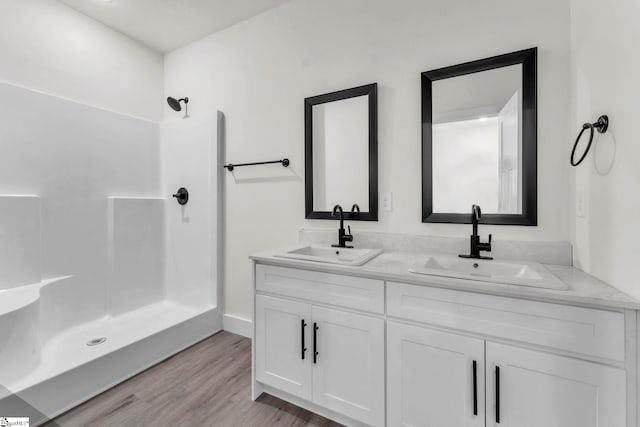 bathroom featuring vanity, wood-type flooring, and walk in shower