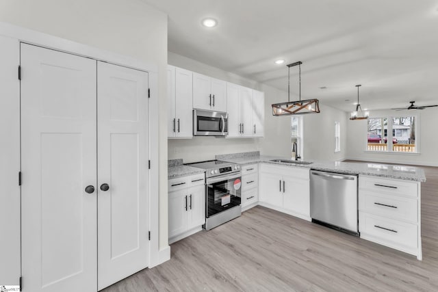 kitchen featuring stainless steel appliances, kitchen peninsula, and white cabinets