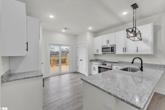 kitchen with sink, hanging light fixtures, kitchen peninsula, stainless steel appliances, and white cabinets