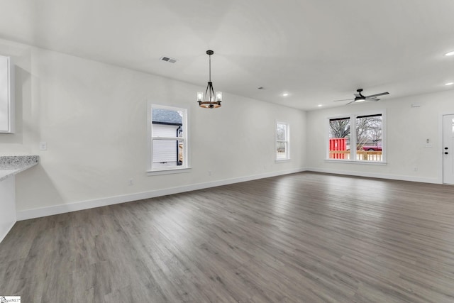 unfurnished living room featuring wood-type flooring and ceiling fan with notable chandelier