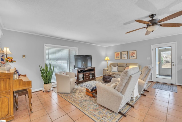 tiled living room with ceiling fan, plenty of natural light, ornamental molding, and a textured ceiling