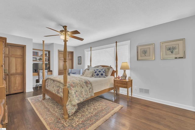 bedroom featuring dark wood-type flooring, ceiling fan, and a textured ceiling