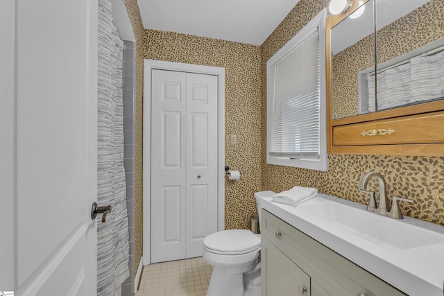 bathroom featuring tile patterned flooring, vanity, and toilet