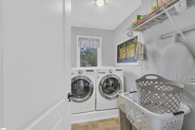 laundry room with washer and dryer and a textured ceiling