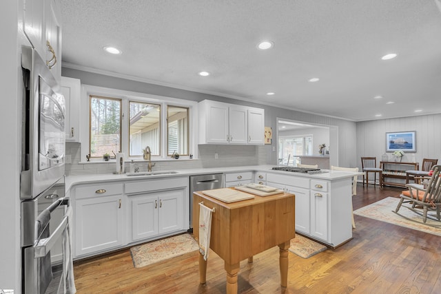 kitchen with white cabinetry, sink, and hardwood / wood-style flooring