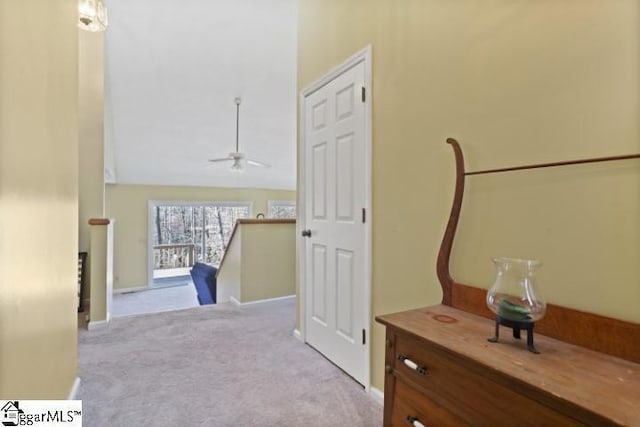 corridor featuring lofted ceiling and light carpet