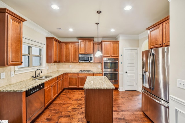 kitchen featuring sink, light stone counters, decorative light fixtures, a center island, and stainless steel appliances