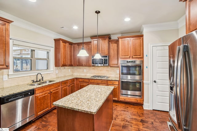 kitchen featuring sink, light stone counters, decorative light fixtures, a center island, and appliances with stainless steel finishes