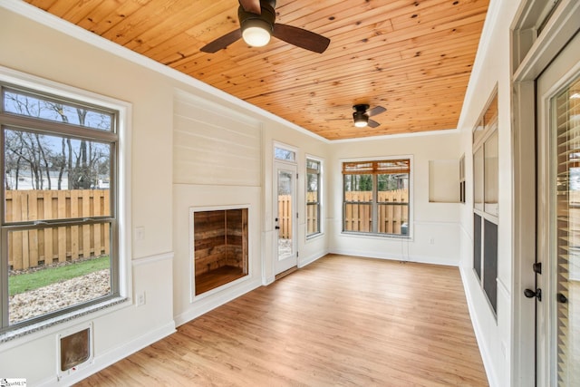 unfurnished sunroom with wooden ceiling and ceiling fan