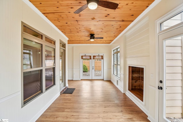 unfurnished sunroom with ceiling fan, wood ceiling, and french doors