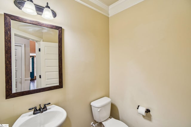 bathroom featuring ornamental molding, sink, and toilet