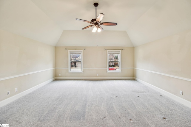 carpeted spare room featuring lofted ceiling and ceiling fan