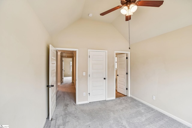 unfurnished bedroom featuring vaulted ceiling, light colored carpet, and ceiling fan