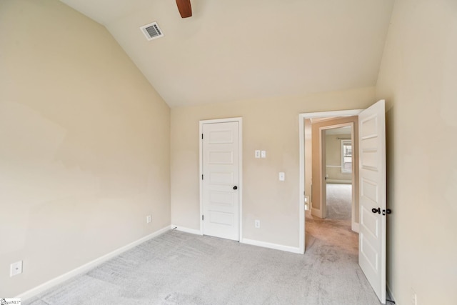 unfurnished bedroom with ceiling fan, light colored carpet, and vaulted ceiling