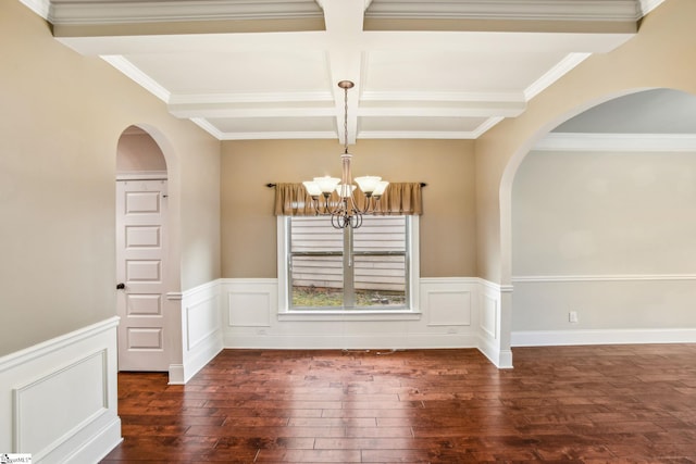 unfurnished dining area featuring beamed ceiling, coffered ceiling, dark hardwood / wood-style floors, and an inviting chandelier