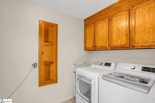 clothes washing area with cabinets and washer and clothes dryer