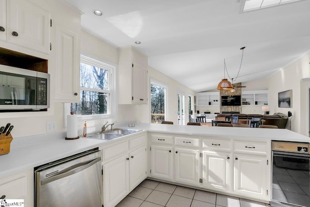 kitchen with white cabinetry, lofted ceiling, sink, kitchen peninsula, and stainless steel appliances