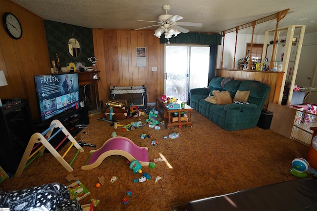 carpeted living room with ceiling fan, a textured ceiling, and wood walls