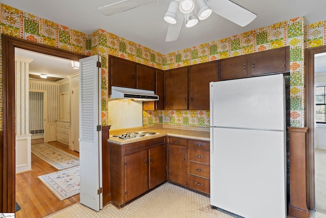 kitchen featuring dark brown cabinetry, ceiling fan, and white appliances