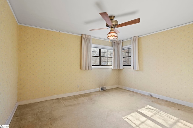 carpeted empty room with crown molding and ceiling fan