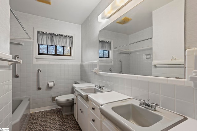 bathroom with vanity, toilet, and tile walls