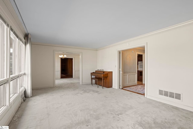 empty room with ornamental molding, light carpet, and an inviting chandelier