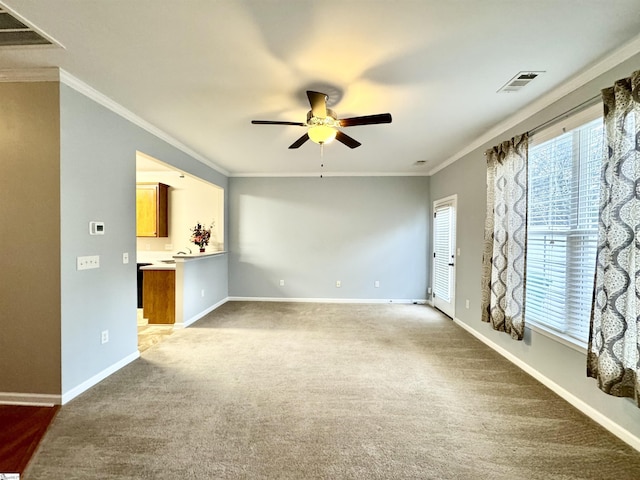 unfurnished living room with ornamental molding, carpet, a wealth of natural light, and ceiling fan