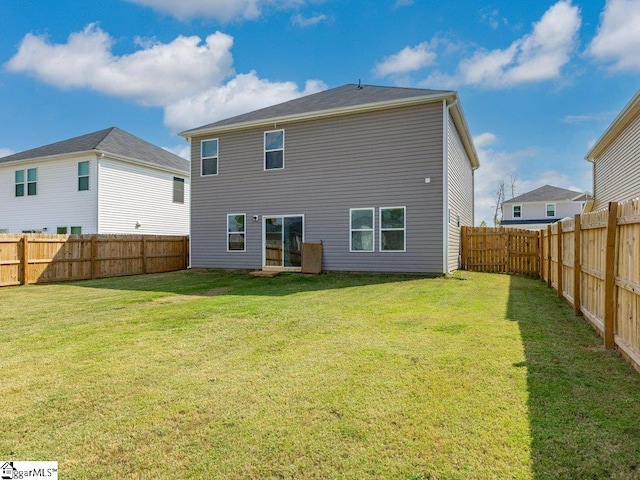 rear view of house featuring a yard