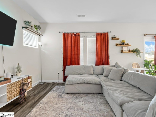 living room with plenty of natural light and dark hardwood / wood-style flooring